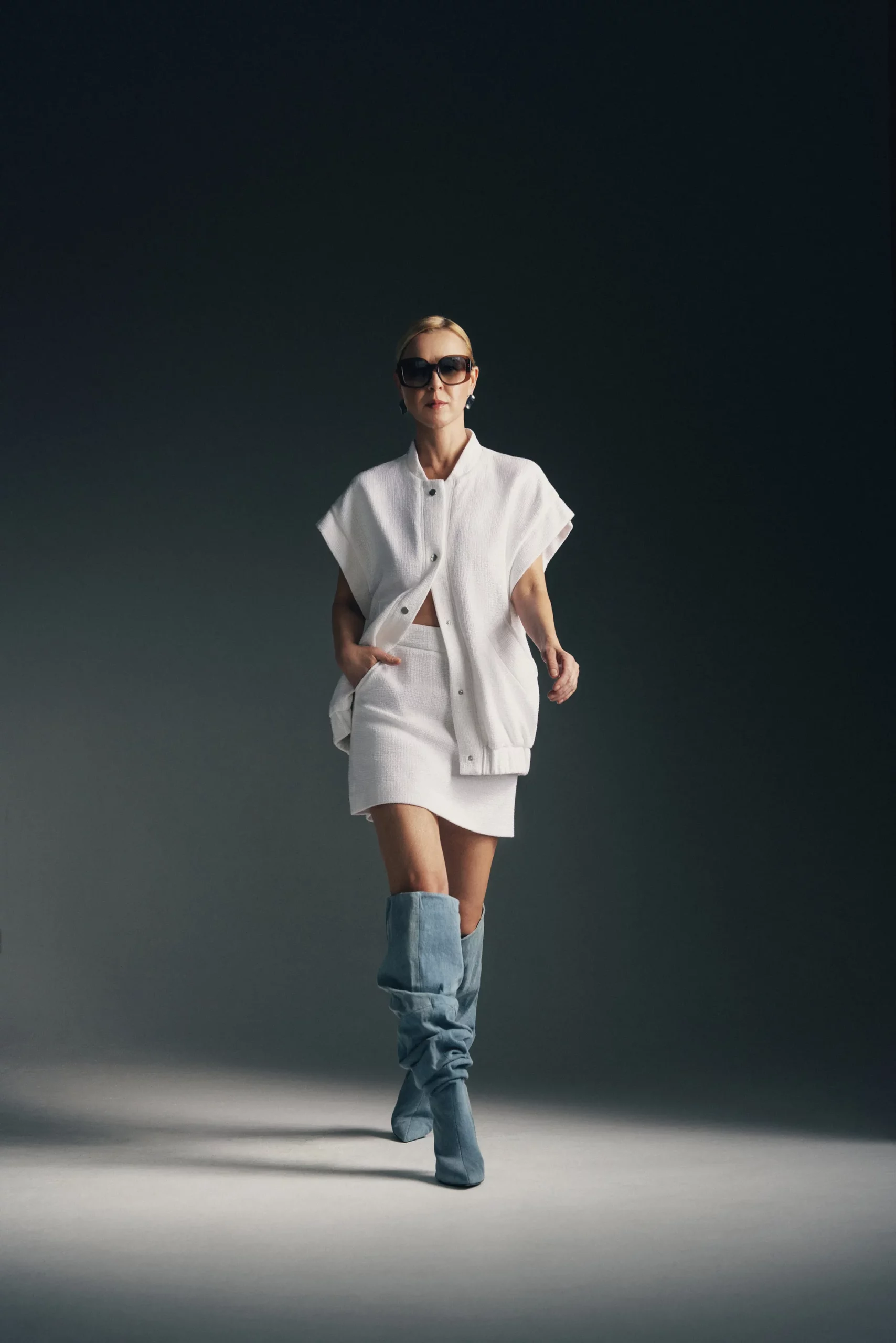 kobieta w białej awangardowej kamizelce i krótkiej białej spódniczce